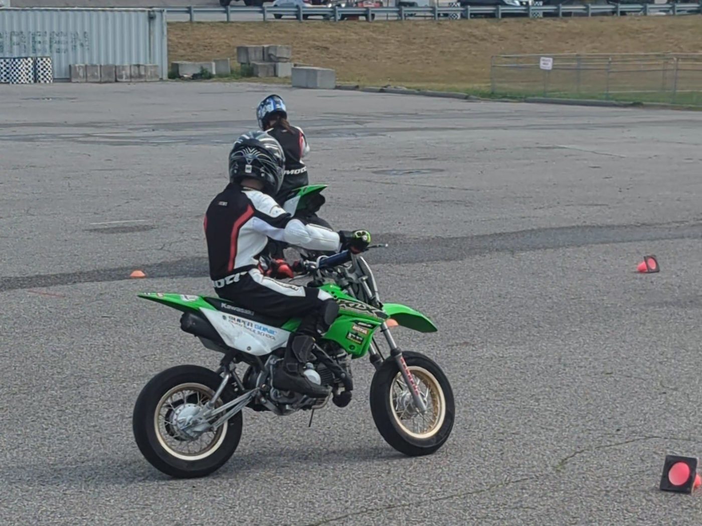 Abel on the school's Kawasaki, Super Sonic sticker on the shroud, with another helmeted rider alongside
